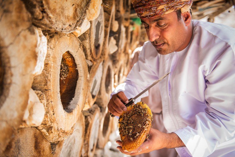 Awad holding a fresh disk of bee wax